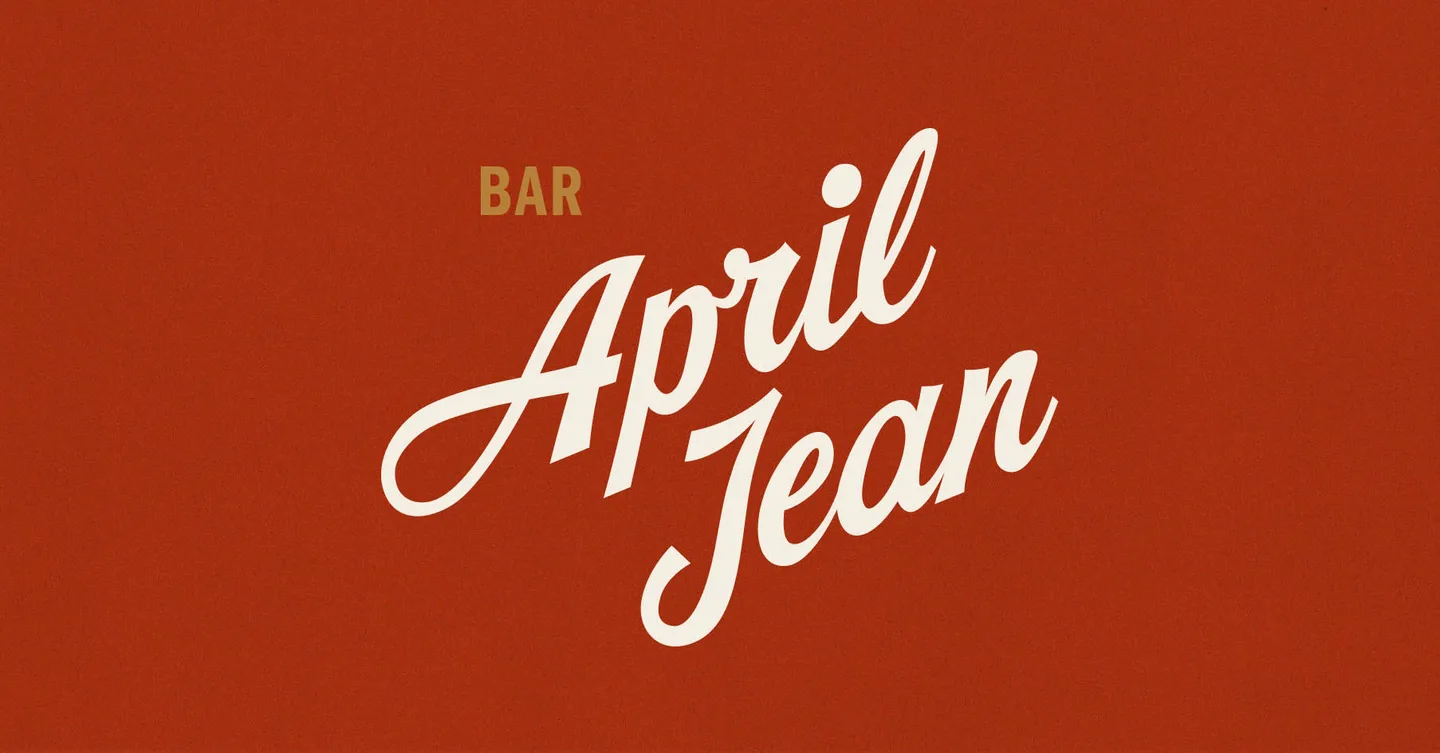 The words Bar April Jean in cream script on a rust-red field.