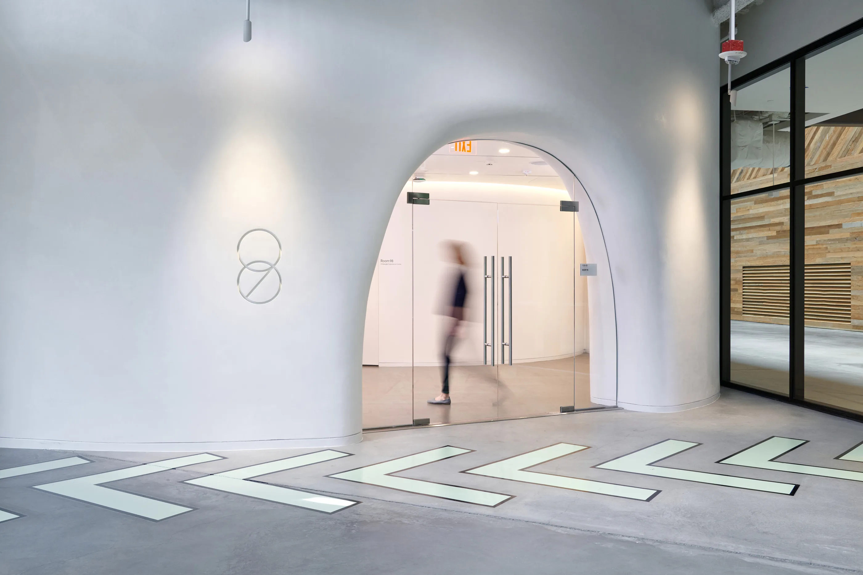 A white arched opening with glowing chevron paving leading into Room 98.