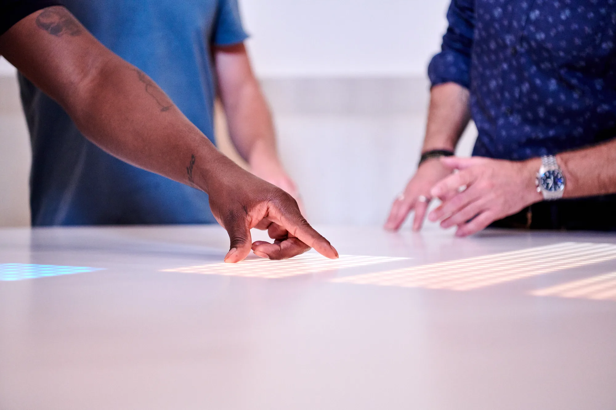 Hands on a table surface lit with bars of light.