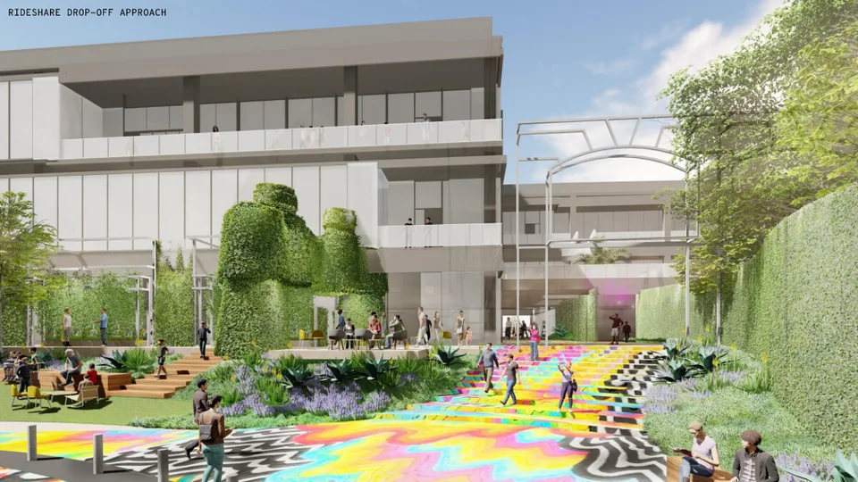 Concept view of a courtyard with a patterned, brightly colored paving, people walking, and a building with a green wall.