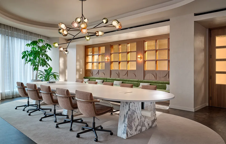 A long stone-based table in the Bellevue board room, beneath a sculptural chandelier.