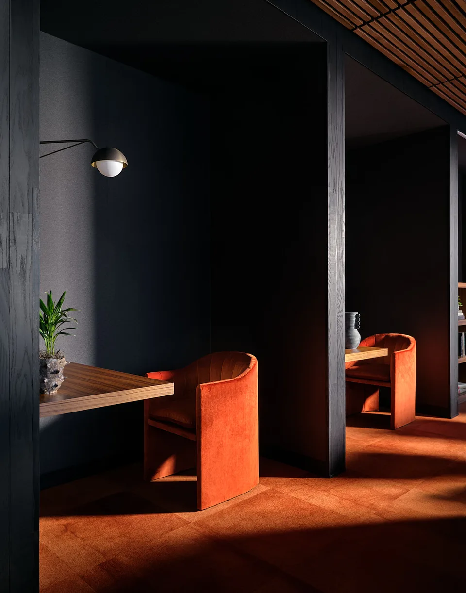 A focus nook in the Bellevue library with a rust-colored chair against dark walls.
