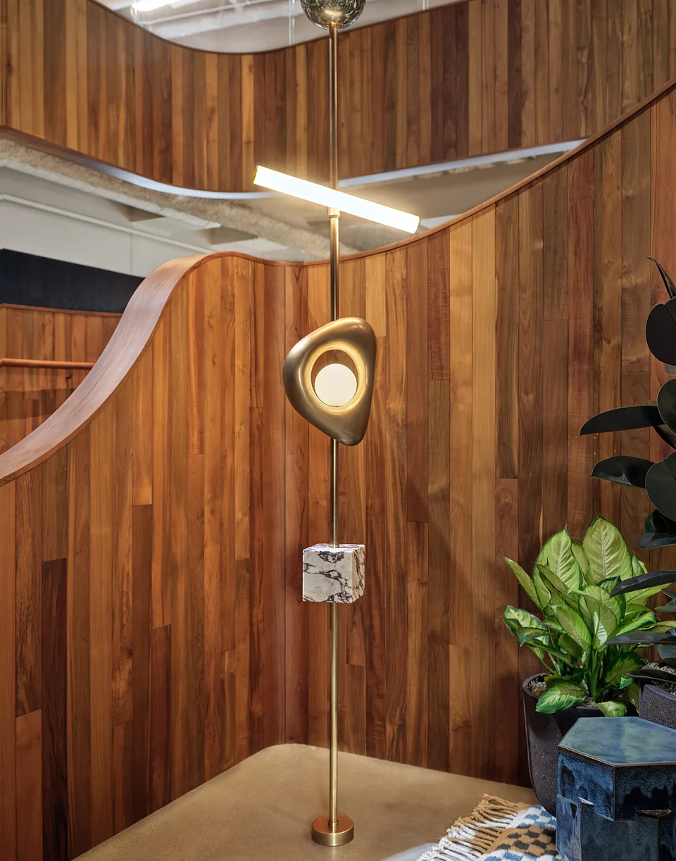 Brass floor lamp beside the curved timber stair wall at Bellevue.