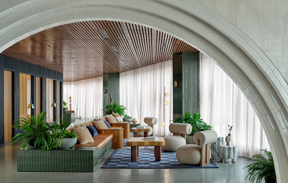 Curved banquette and low tables under a slatted timber ceiling at Bellevue.