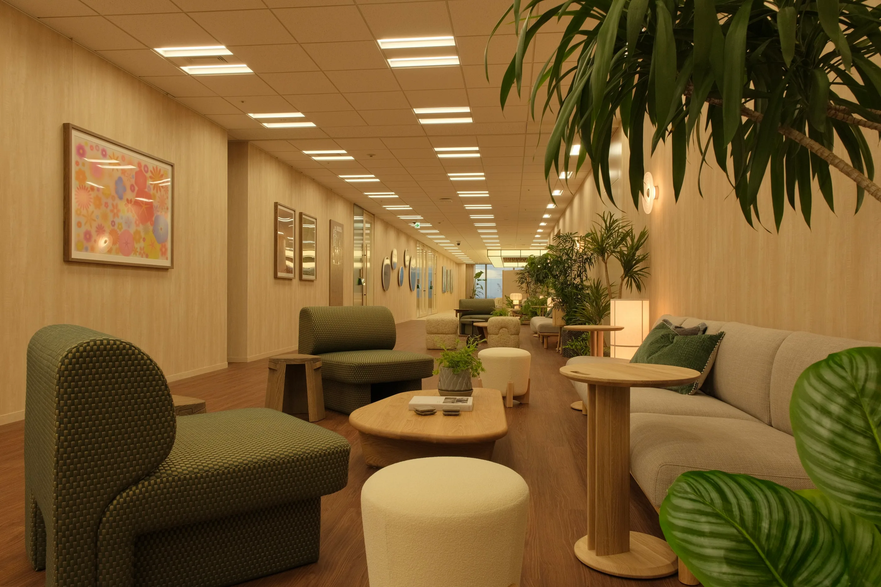 A long timber-walled room with lounge seating and plants.