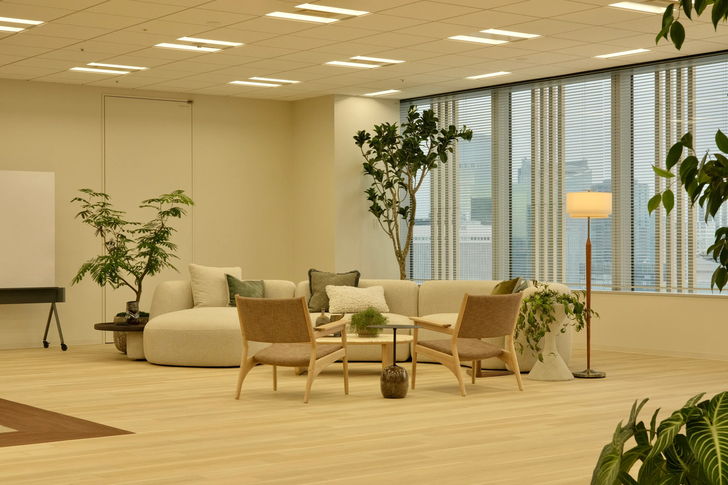 Dark green sofas and low tables beside a row of workstations.