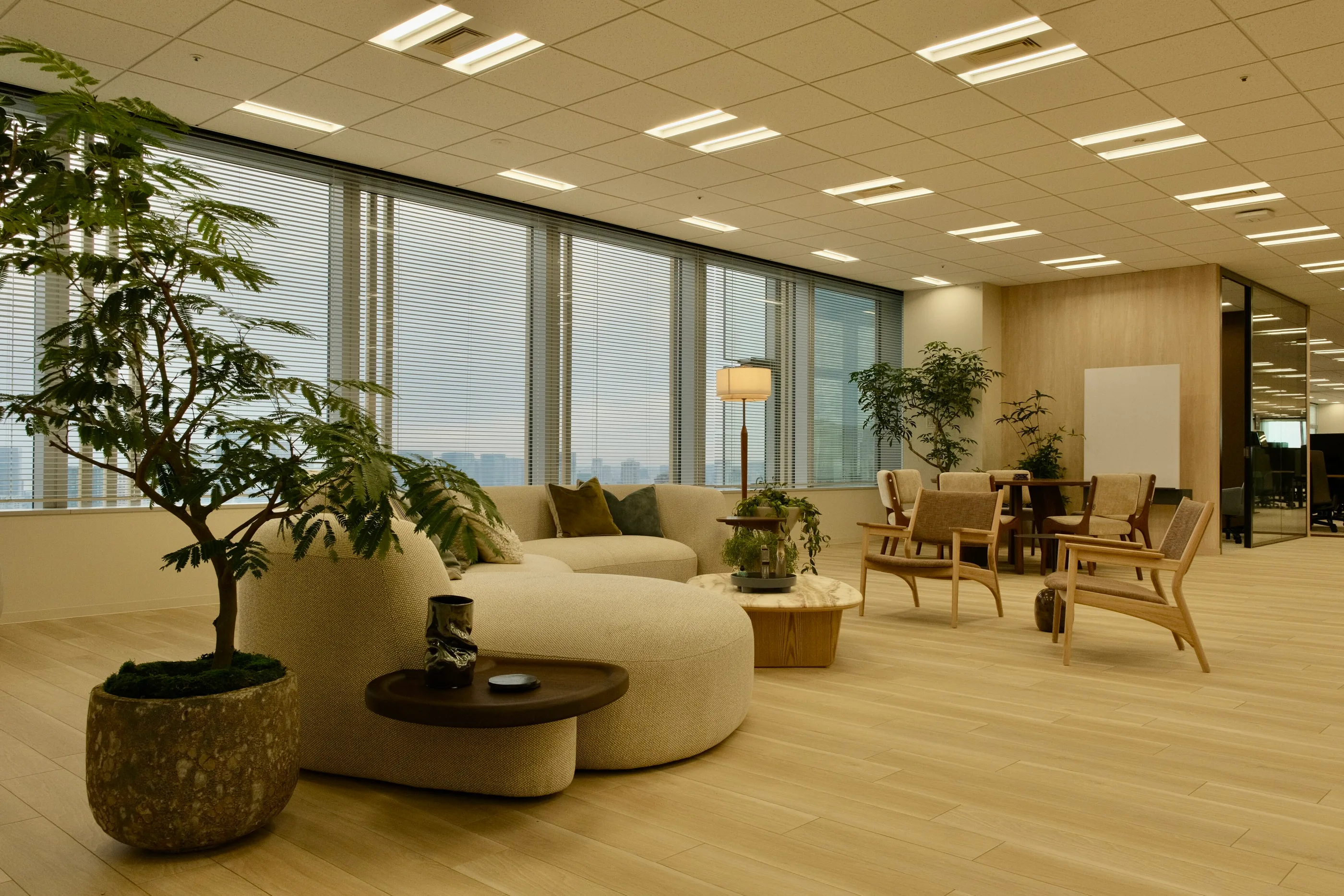 Open work floor with lounge seating, plants and desks.